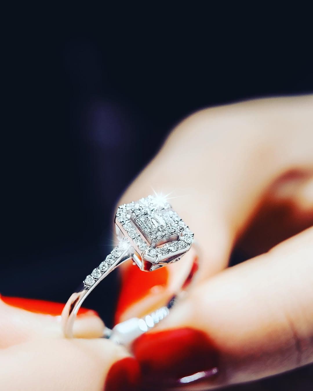 Woman with long dark hair wearing medallion necklace and sunglasses