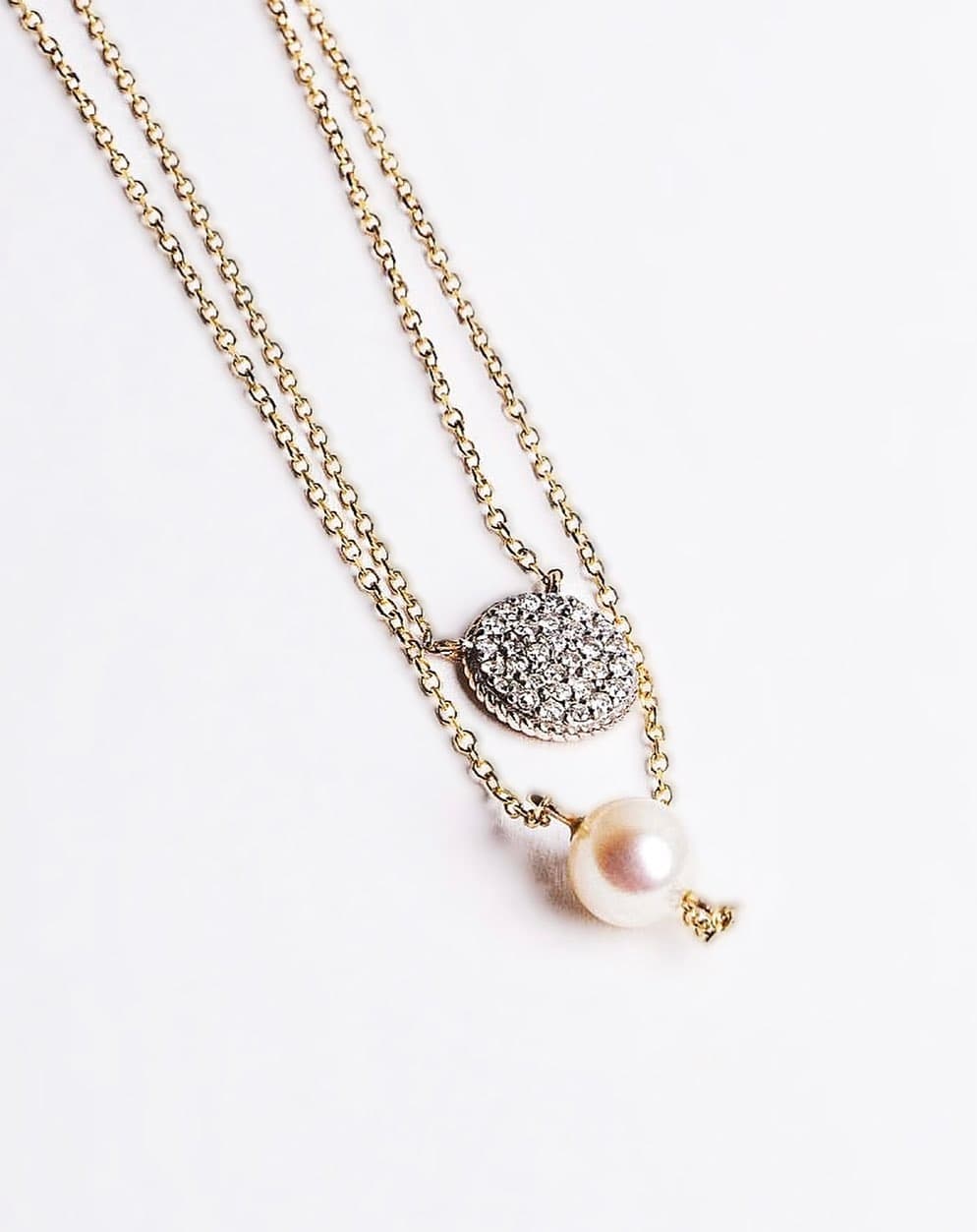 Smiling woman with blonde hair wearing gold pendant necklace outdoors